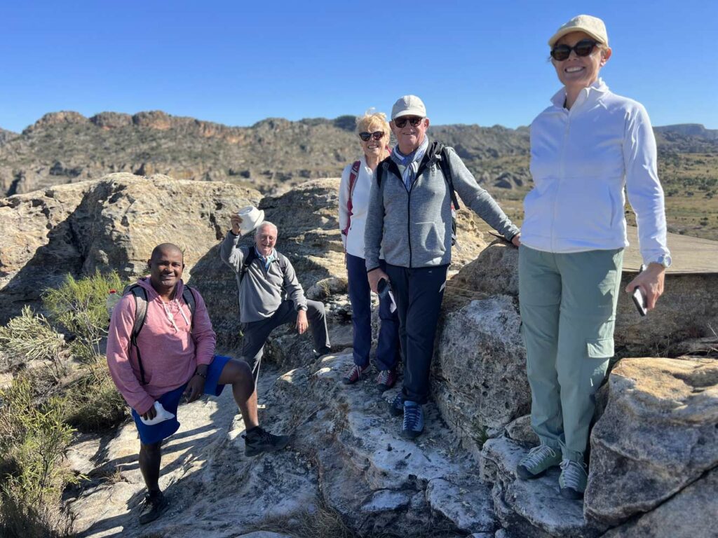Guide malgache accompagne des touristes lors d’une randonnée à travers les collines
