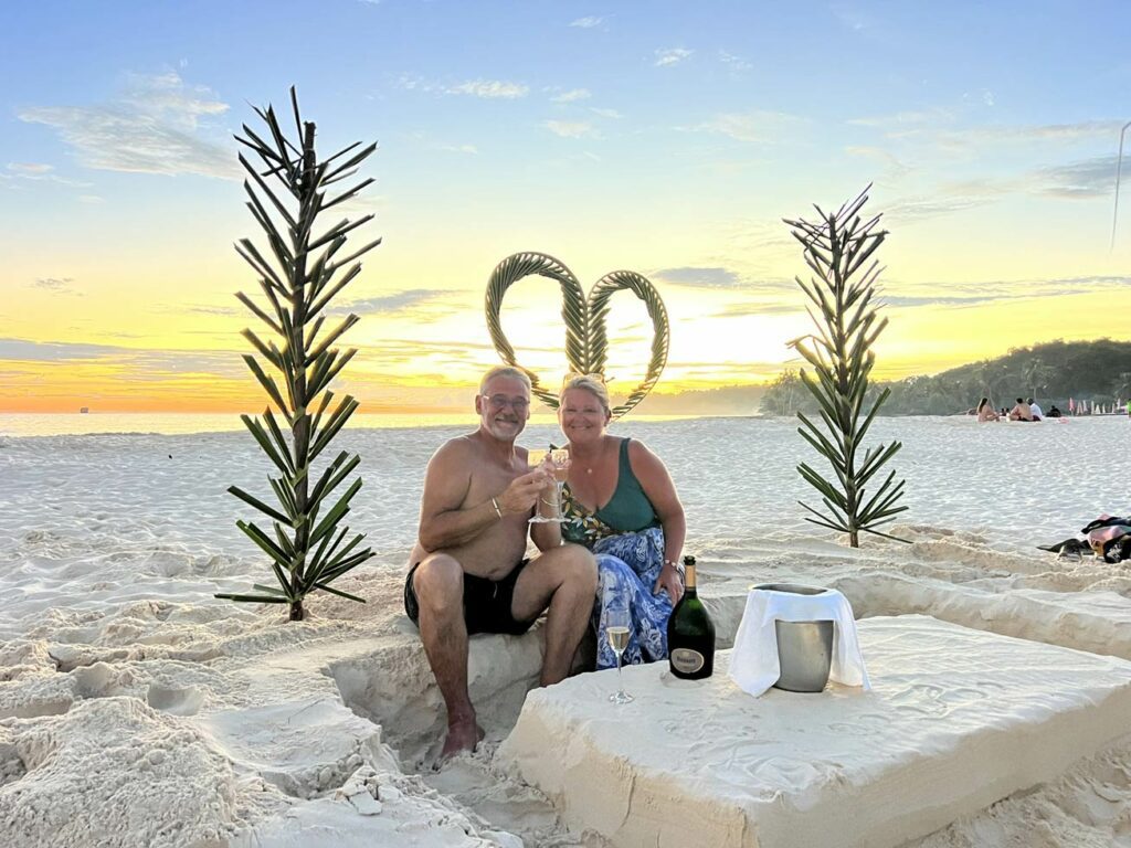 Couple en lune de miel marchant sur une plage privée de sable blanc à Nosy Be, Madagascar